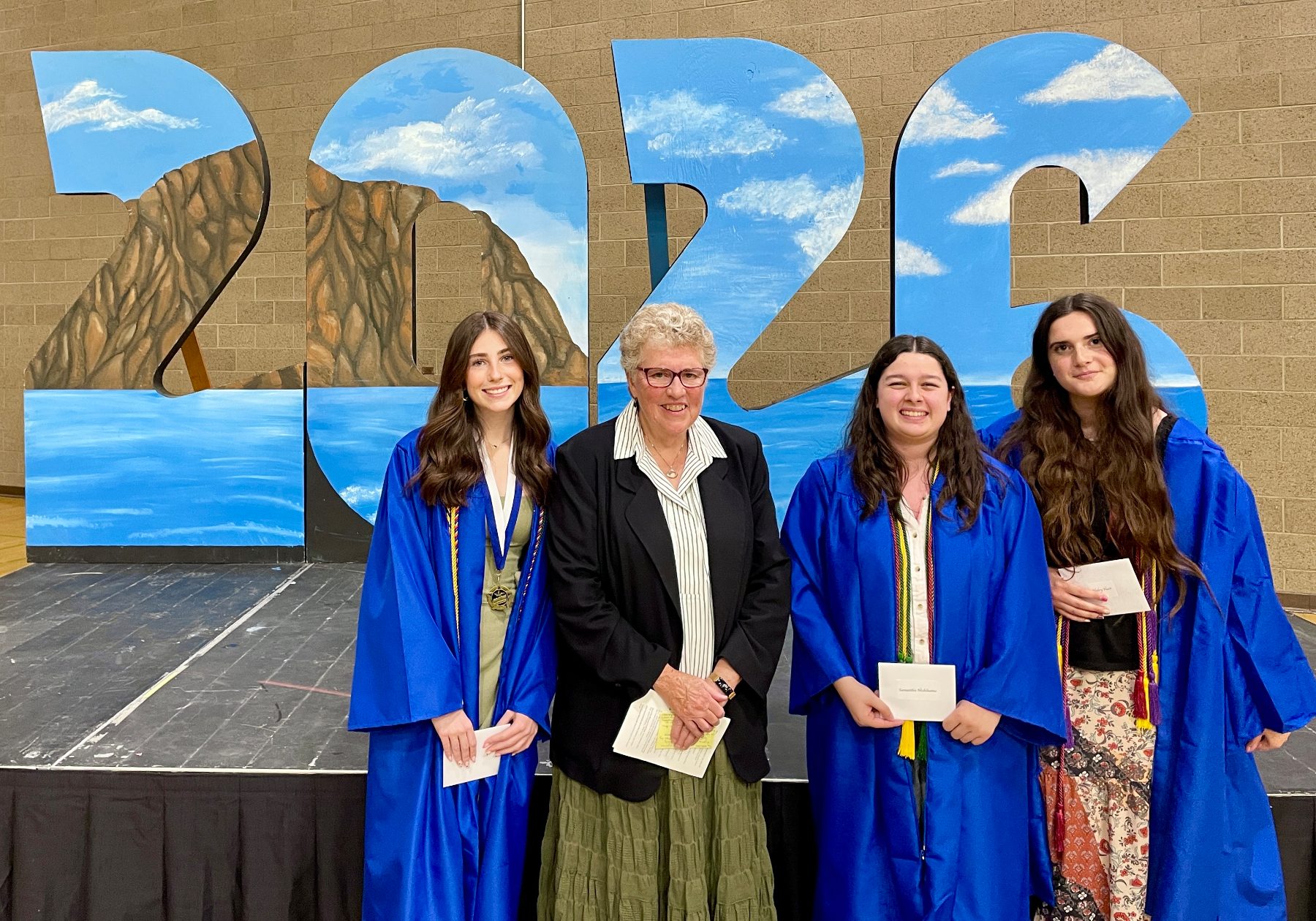 Community Liaison Holly Danks (second from left) awards MBWGC scholarships to Ashley Beltrama, Sammy Nishihama and Haley Hart. (Missing is Willa Turton.)